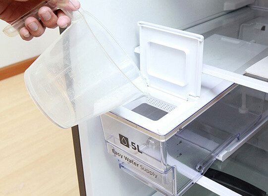 Đổ nước vào hộp chứa bên trong tủ lạnh.