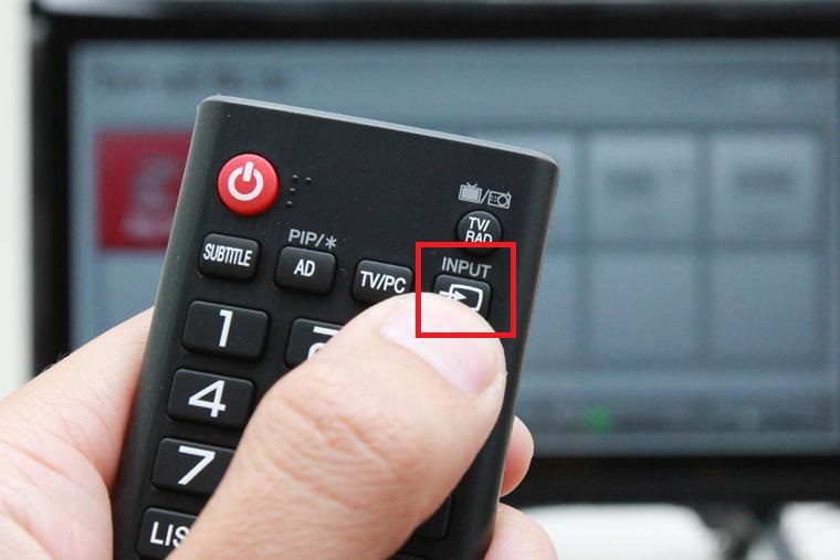 Chọn nguồn bằng cách nhấn nút SOURCE hoặc INPUT trên remote tivi
